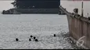 Para bocah pelabuhan ini menunggu para pemudik melempar koin ke laut. Aksi rebutan koin menjadi hiburan bagi pemudik, Banten, Jumat (25/07/2014) (Liputan6.com/JohanTallo)