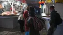 Orang-orang berjalan untuk membeli daging di Pasar Rodriguez, La Paz, pada 16 November 2019. Pemblokiran jalan yang dilakukan pendukung mantan Presiden Bolivia Evo Morales membuat kelangkaan bahan makanan, terutama daging dan telur, mulai sulit ditemukan di pasar. (AIZAR RALDES/AFP)