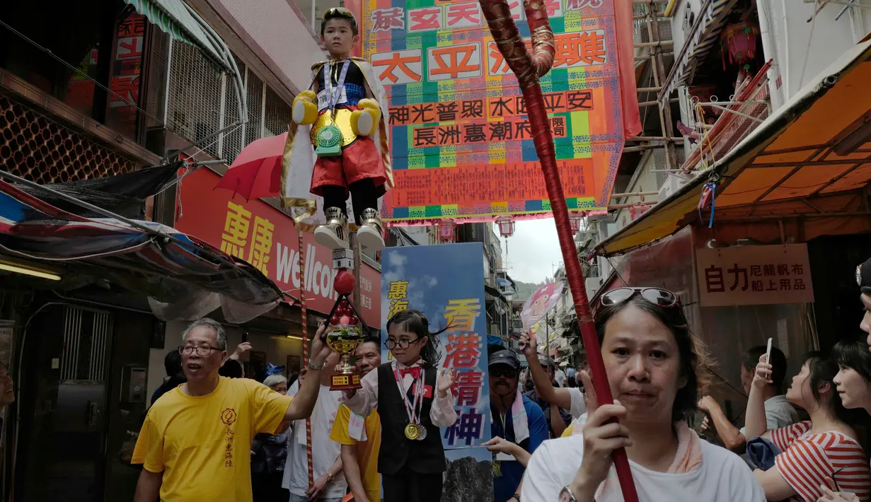 Sejumlah anak-anak mengenakan kostum diarak saat perayaan Festival Cheung Chau Bun di Hong Kong (5/3). Pada saat melakukan festival ini masyarakat pulau Cheung Chau membawa sebuah patung dewa Pak Tai dari satu desa ke desa lain. (AP Photo/Vincent Yu)