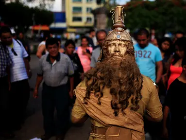 Seorang kontestan beraksi saat mengikuti kontes patung di pusat kota San Salvador , El Salvador, (18/6). Kontes ini menjadi tontonan warga El Savador yang sedang melintas. (REUTERS / Jose Cabezas)