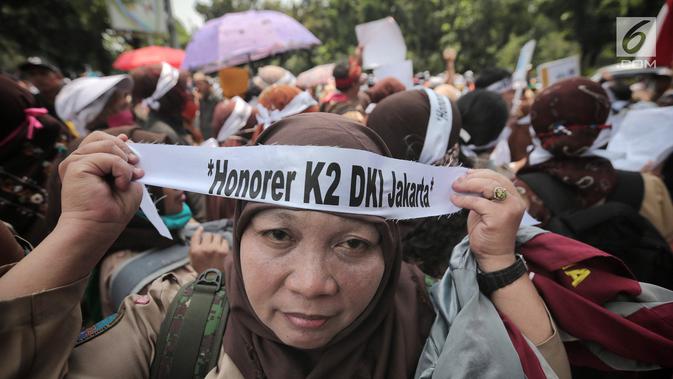 Pegawai honorer DKI Jakarta menggelar demo di Balai Kota, Jakarta, Rabu (26/9). Massa mengenakan seragam pramuka dan membawa sejumlah poster aspirasi. (Liputan6.com/Faizal Fanani)