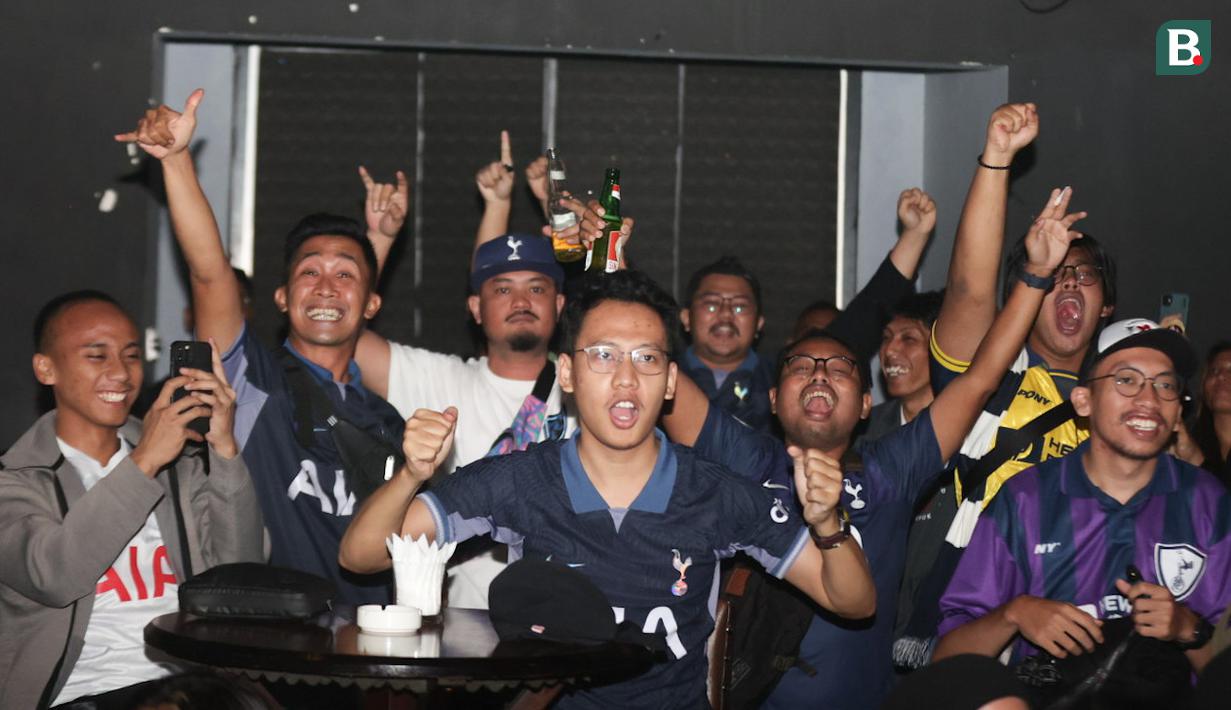 Para penggemar Tottenham Hotspur bersorak saat tim kesayangannya mencetak gol ke gawang Arsenal dalam acara nonton bareng Roaring Night Liga Inggris 2023/2024 di Treehaus Kemang, Minggu (28/4/2024) malam WIB yang digelar komunitas penggemar Tottenham Hotspur, IndoSpurs Jakarta. (Bola.com/Abdul Aziz)