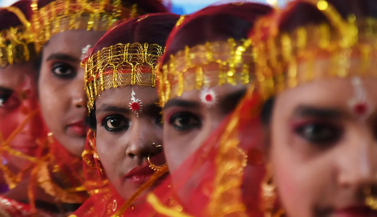 Sejumlah wanita calon pengantin bersiap mengikuti upacara pernikahan massal di Kolkata, India (14/2). Lebih dari 160 pasangan yang mengalami kesulitan ekonomi mengikuti acara nikah massal tersebut. (AFP Photo/Dibyangshu Sarkar)