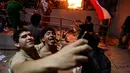 Demonstran berselfie saat unjuk rasa di Asuncion, Paraguay (31/3). Selain menghancurkan gedung Kongres para pengunjuk rasa menjarah dan mengacak-acak file yang ada di dalam kantor tersebut. (AP Photo/Jorge Saenz)