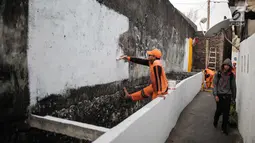 Petugas PPSU menyelesaikan pengerjaan jalur peningkatan aksesibilitas jalan lokal dan kampung menuju Stasiun MRT di Gang Teladan, Cipete Raya, Jakarta, Senin (2/9/2019). Hal ini untuk meningkatkan keamanan bagi pejalan kaki dan pesepeda menuju Stasiun MRT Cipete Raya. (Liputan6.com/Faizal Fanani)