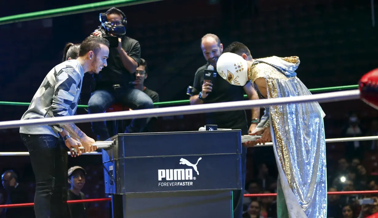 Lewis Hamilton bermain sepakbola meja dengan seorang bintang WWE di Coliseo Arena, Mexico City, (28/10/2015). (Reuters/Henry Romero)