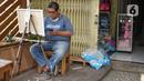 Seorang pria melukis di Gembrong Baru, Jalan Jenderal Basuki Rachmat, Jakarta Timur, Minggu (16/8/2020). Pasar yang dulu diisi kios-kios mainan anak dan boneka tersebut kini berubah wajah menjadi galeri bagi para perupa, barang antik, hingga buku-buku lawas. (Liputan6.com/Immanuel Antonius)