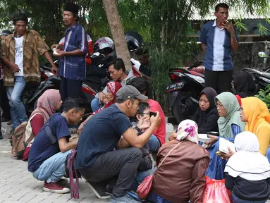 Keluarga korban tewas dalam kebakaran pabrik kembang api di Kosambi, Kabupaten Tangerang, Banten pada Kamis (26/10/2017), menunggu di sekitar Posko Ante Mortem RS Polri Sukanto Kramat Jati, Jakarta Timur, Jumat (27/10). (Liputan6.com/Immanuel Antonius)