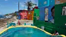 Wisatawan menaiki tangga saat mengunjungi lokasi syuting video klip Despacito di La Perla, San Juan, Puerto Rico, 22 Juli 2017. Despacito mampu menaikkan pamor Puerto Rico karena disebut secara terang-terangan dalam lirik lagu ini. (Ricardo ARDUENGO/AFP)