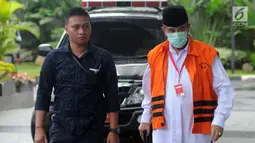 Bupati Bandung Barat Abubakar mengenakan masker dan tongkat berjalan saat tiba di gedung KPK, Jakarta, Selasa (24/4). Abubakar diperiksa perdana pasca penahanan oleh KPK. (Merdeka.com/Dwi Narwoko)