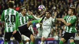 Striker Real Madrid, Alvaro Morata, berebut bola dengan penyerang Real Betis, Dani Ceballos. Pada laga ini Los Blancos turun dengan formasi 4-4-2, sementara Real Betis memakai 5-3-2. (AFP/Gerard Julien)