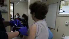 Warga disuntik vaksin COVID-19 Pfizer-BioNTech di dalam van yang digunakan sebagai unit vaksinasi bergerak di pelabuhan Piraeus, Athena, Senin (13/12/2021). Yunani meningkatkan vaksinasi kampanye menjelang liburan Natal ketika negara itu bergulat dengan lonjakan infeksi. (AP/Thanassis Stavrakis)