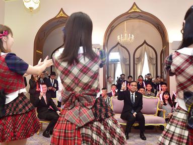 Perdana Menteri Thailand, Prayut Chan-O-Cha menyaksikan grup musik Jepang, AKB48, tampil di Gedung Pemerintahan, Kamis (13/8). Kunjungan ini adalah promosi AKB48 untuk mempersiapkan konser di Bangkok pada Desember mendatang. (HO/ROYAL THAI GOVERNMENT/AFP)