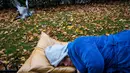 Aktivis tidur di bangku taman di pusat kota Bratislava untuk mengekspresikan solidaritas kepada tunawisma di Hungaria, 8 November 2018. Pasalnya tidur di tempat umum dilarang setelah undang-undang tunawisma diadopsi oleh pemerintah. (VLADIMIR SIMICEK/AFP)