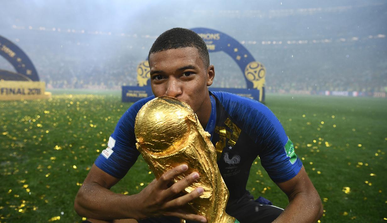 Striker Prancis, Kylian Mbappe, mencium trofi Piala Dunia usai menjadi juara Piala Dunia 2018 di Luzhniki Stadium, Moscow, (15/6/2018). Prancis menang 4-2 atas Krosia. (AFP/Franck Fife)