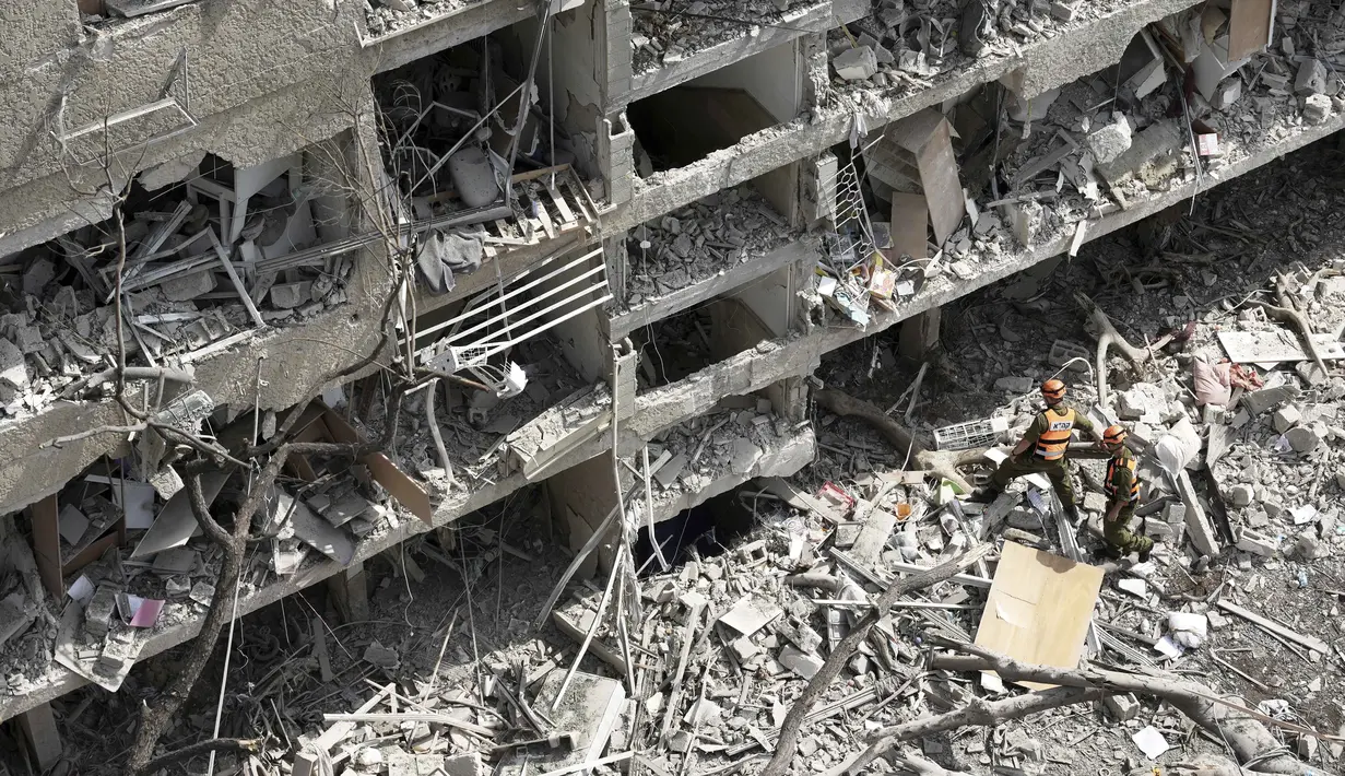 Perwira komando garis depan Israel meninjau lokasi serangan rudal langsung yang diluncurkan dari Iran di Tel Aviv, Minggu 22 Juni 2025. (AP/Oded Balilty)