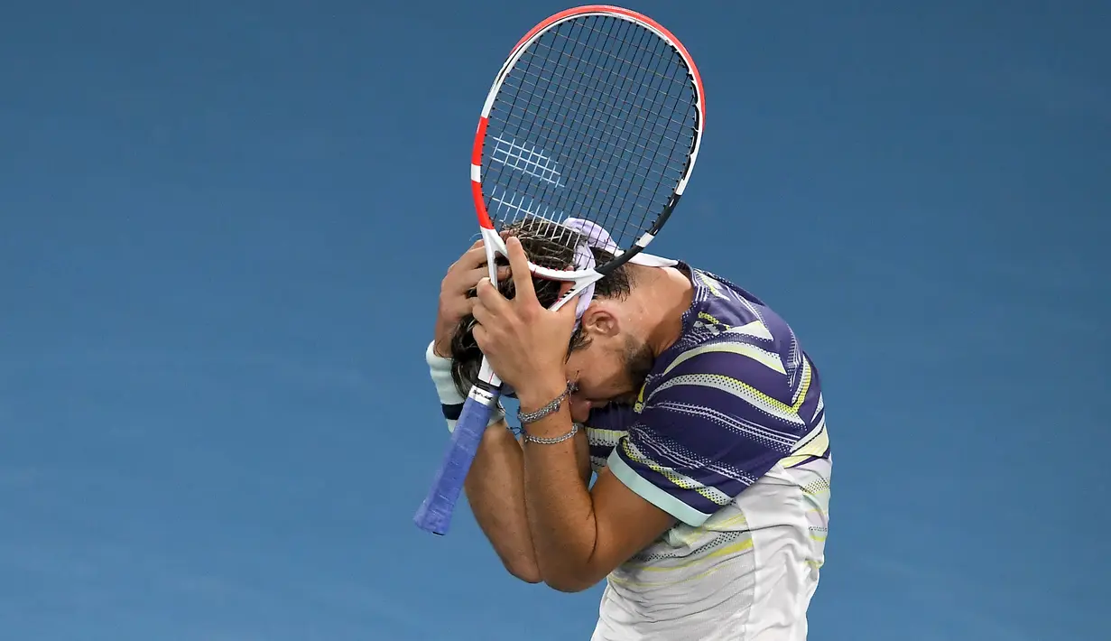 Petenis Austria Dominic Thiem memegang kepalanya merayakan kemenangan usai mengalahkan Rafael Nadal dari Spanyol pada pertandingan perempat final Australia Terbuka 2020 di Melbourne (29/1/2020). (AFP Photo/Greg Wood)