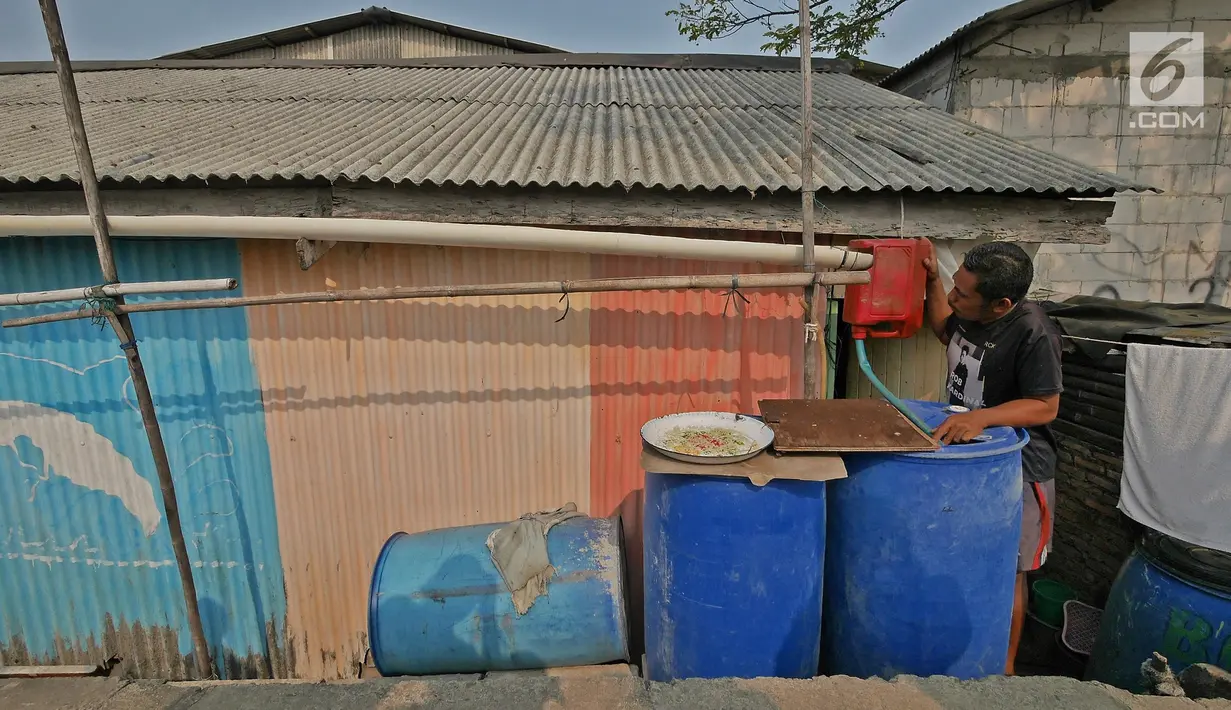 Warga memeriksa talang yang menyalurkan air ke dalam tong di kawasan Kampung Kamal Muara, Jakarta, Selasa (9/7/2019). Saat musim kemarau, warga Kampung Kamal Muara harus membeli air seharga Rp 5.000 per jeriken untuk kebutuhan mandi, cuci pakaian dan lain-lain. (Liputan6.com/Herman Zakharia)