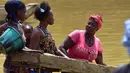 Para penambang emas wanita bekerja di sungai Pampana di dekat Mekeni, sebelah utara Sierra Leone (5/3). Melintasi tanah yang curam, ratusan pria dan wanita di sungai menyaring kerikil, memisahkan bintik-bintik emas dari lumpur. (AFP Photo/Issouf Sanogo)