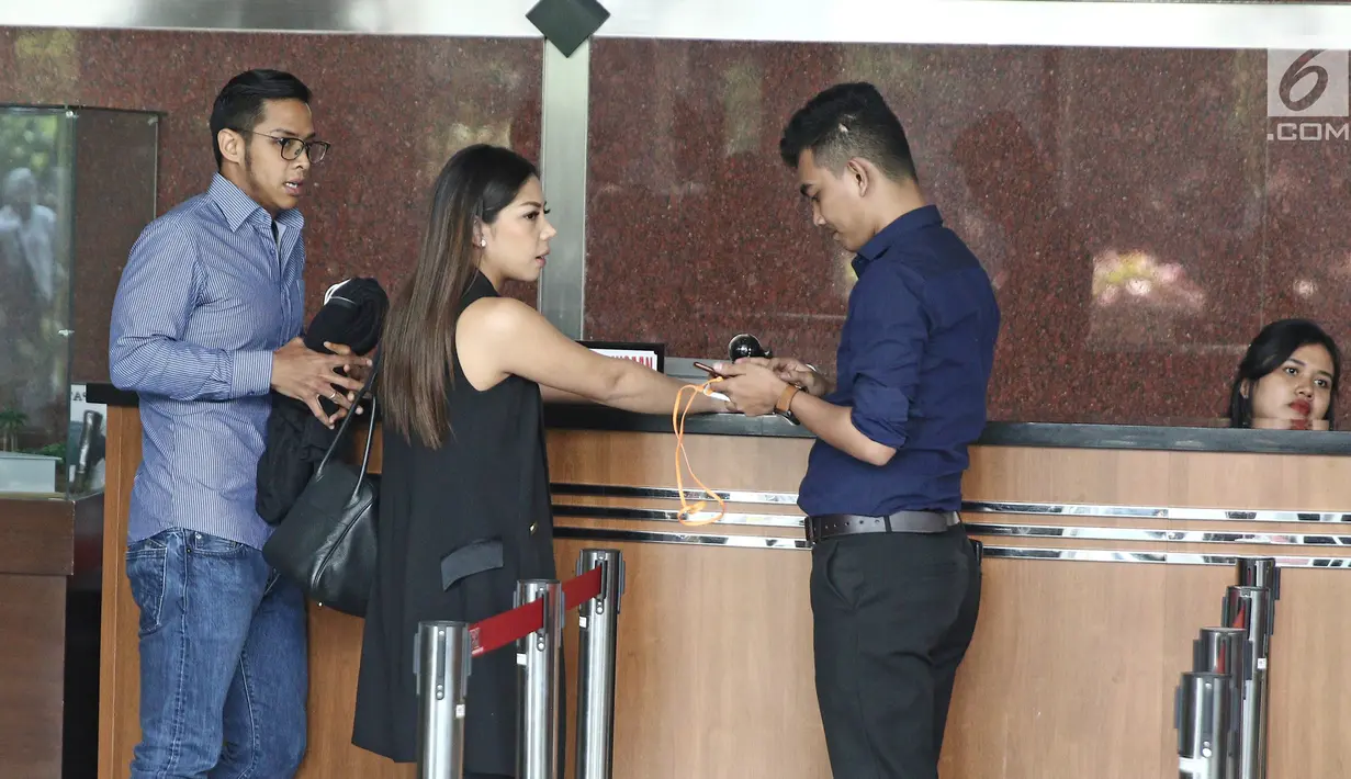 Dwina Michaella dan Rheza Herwindo mengisi buku tamu usai menjalani pemeriksaan di gedung KPK, Jakarta, Rabu (28/3). Dwina dan Rheza diperiksa sebagai saksi untuk tersangka Irvanto Hendra Pambudi Cahyo dan Made Oka Masagung. (Liputan6com/Herman Zakharia)