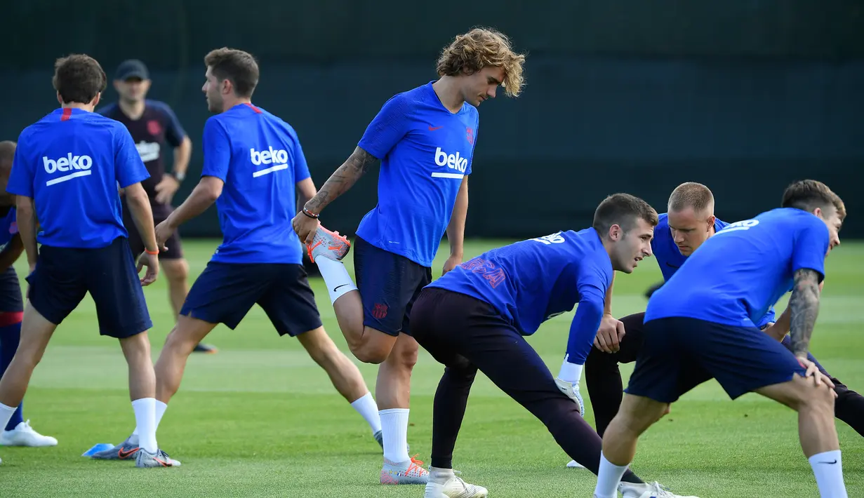 Penyerang baru Barcelona, Antoine Griezmann melakukan pemanasan selama latihan pramusim pertama di Joan Gamper, Barcelona (15/7/2019). Griezmann resmi menjadi pemain Barcelona usai diboyong dari Atletico Madrid. (AFP Photo/Lluis Gene)