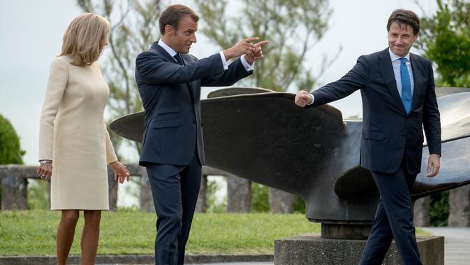 Presiden Prancis Emmanuel Macron (tengah) dan istrinya Brigitte Macron (kiri) menyambut kedatangan pemimpin sementara Italia Giuseppe Conte di KTT G7, Biarritz, Prancis, Sabtu (24/8/2019). (AP Photo/Andrew Harnik)