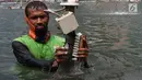 Petugas membersihkan kolam Patung Selamat Datang di kawasan Bundaran HI, Jakarta, Kamis (23/8). Pembersihan dilakukan dalam rangka perawatan rutin guna menjaga keindahan estetika kota. (Liputan6.com/Immanuel Antonius)