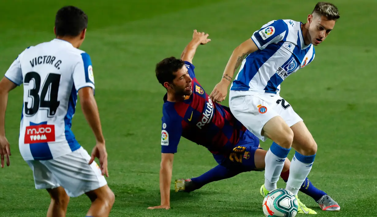 Bek Barcelona, Sergi Roberto, berebut bola dengan pemain Espanyol, Pol Lozano pada lanjutan pertandingan La Liga Spanyol di Camp Nou, Kamis (9/7/2020) dini hari WIB.  Barcelona menang tipis 1-0 atas Espanyol lewat gol yang dicetak Luis Suarez. (AP Photo/Joan Monfort)