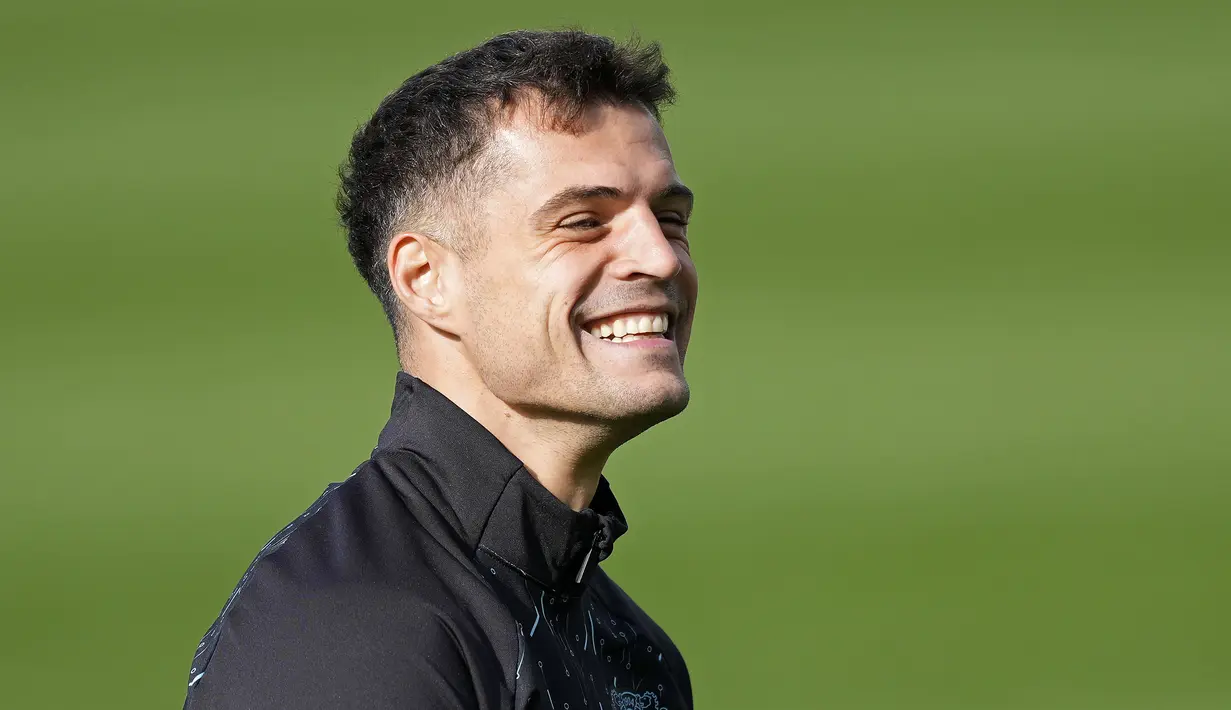 Pemain Bayer Leverkusen, Granit Xhaka, tersenyum saat sesi latihan jelang laga melawan AC Milan pada laga Liga Champions. (AP Photo/Martin Meissner)