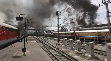 Asap mengepul dari kereta api yang dibakar pengunjuk rasa di stasiun kereta api Secundrabad di Hyderabad, India, Jumat (17/6/2022). Ratusan pemuda melampiaskan kemarahan dengan membakar gerbong kereta, merusak properti kereta api dan memblokir rel dan jalan raya dengan batu-batu besar sebagai serangan balasan. (AP Photo/Mahesh Kumar A)