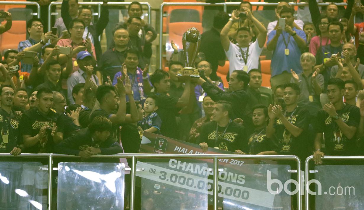 Presiden Republik Indonesia, Joko Widodo menyerahkan trofi Piala Presiden 2017 kepada Kapten Arema FC, Johan Farizi di Stadion Pakansari, Bogor, Minggu (12/3/2017). (Bola.com/Nicklas Hanoatubun)