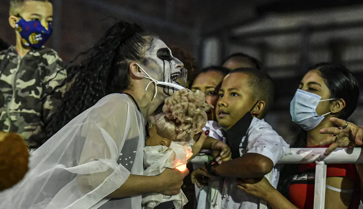 Seorang anak menyaksikan parade Mitos dan Legenda di Medellin, Kolombia (8/12/2021). Kolombia memiliki cerita rakyat tradisional dan cerita tentang makhluk legendaris, yang ditransmisikan secara lisan dan diteruskan ke generasi baru. (AFP/Joaquin Sarmiento)