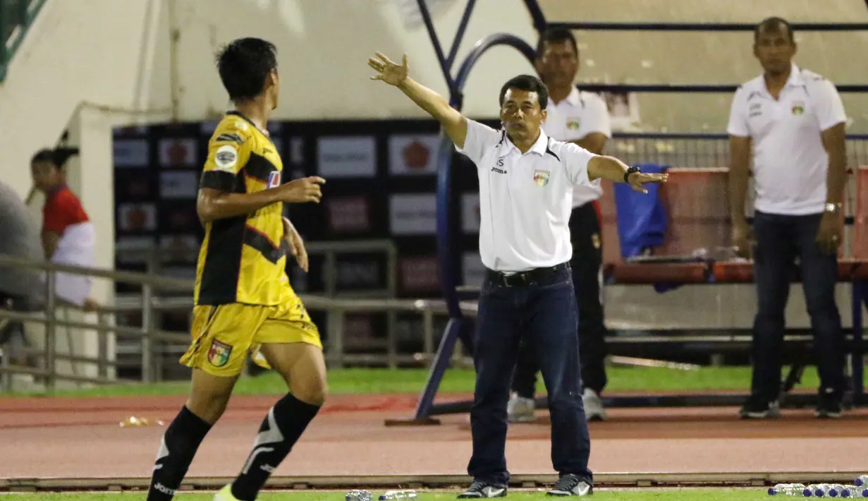 Pelatih Mitra Kukar, Jafri Sastra (2kanan) memberikan Instruksi kepada para pemainnya Pada laga Piala Jenderal Sudirman grup D di Stadion Manahan, Solo, Sabtu (12/12/2015). (Bola.com/Nicklas Hanoatubun)