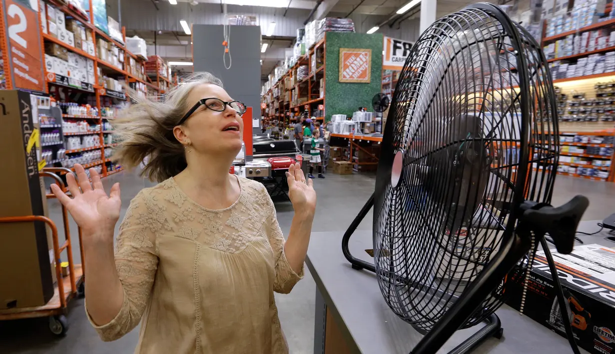 Davi Sobotta bereaksi saat mencoba kipas meja menjelang gelombang panas di toko perlengkapan Home Depot di Seattle, Selasa (1/8). Peringatan cuaca panas yang berlebihan untuk wilayah itu dimulai pada Selasa sore dan hingga Jumat malam (AP/Elaine Thompson)
