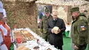 Presiden Rusia Vladimir Putin memeriksa makanan prajurit saat memantau latihan militer Vostok 2018 di Siberia Timur, Rusia, Kamis (13/9). Latihan ini juga diikuti militer China dan Mongolia. (Alexei Nikolsky, Sputnik, Kremlin Pool Photo via AP)