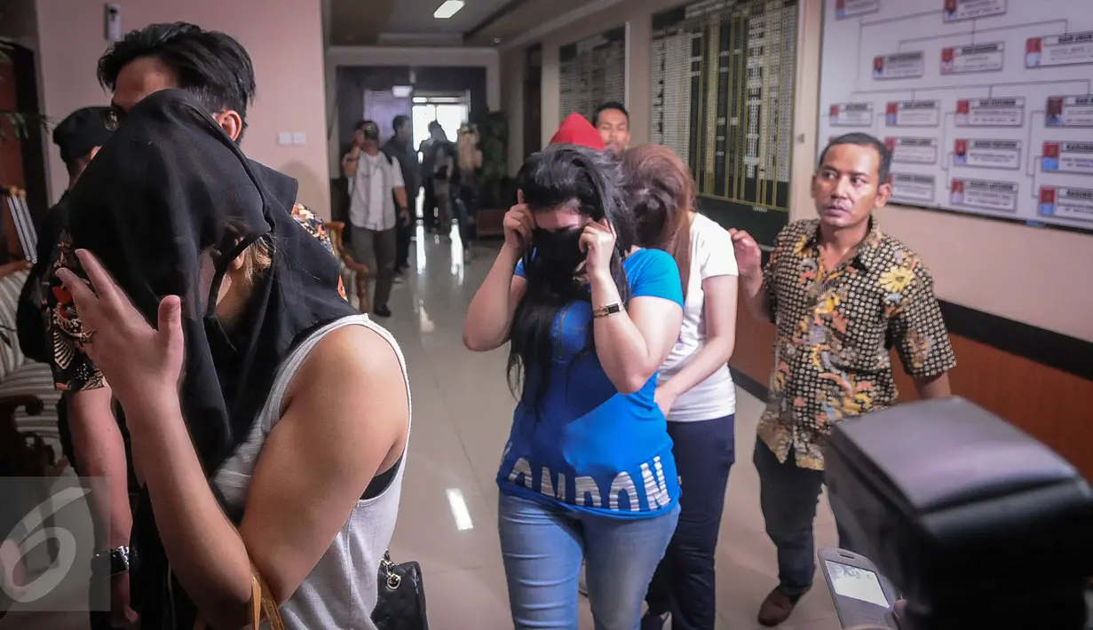 Sejumlah wanita digiring petugas menuju ruang konferensi pers di Imigrasi Kelas I Jakarta Pusat, Jumat (21/10). Sebanyak 17 WNA asal Maroko berusia 20 - 29 tahun diciduk petugas imigrasi di salah satu diskotek kawasan Senayan. (Liputan6.com/Faizal Fanani)