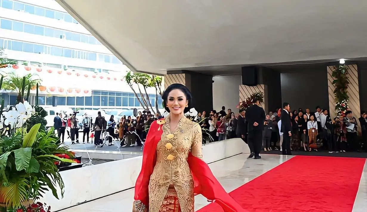 Penampilan Krisdayanti kenakan kebaya brokat emas tak kalah memesona. Paduan selendang dan kain songket merah menambah kesan glamor pada penampilannya. [@krisdayantilemos].