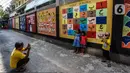 Anak-anak foto di dekat mural edukasi di Jalan Pademangan 2, Jakarta, Senin (18/11/2019). Mural edukasi ini dikerjakan anak-anak muda yang tergabung dalam Tim Mural Pademangan Timur, dengan tujuan memberikan edukasi positif kepada anak-anak di sekitar kawasan itu. (Liputan6.com/Faizal Fanani)