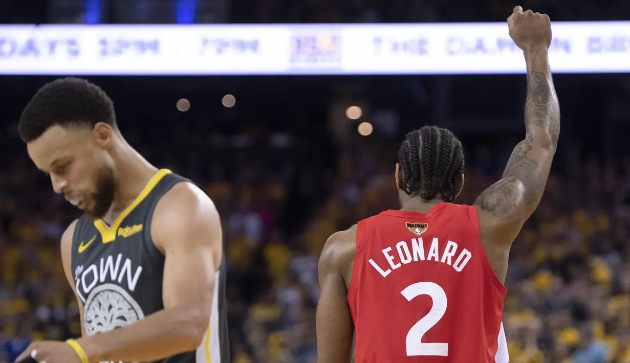 Stephen Curry (kiri) dan Kawhi Leonard dari Toronto Raptors, ekspresi yang bertolak belakang dari dua pebasket andalan masing-masing klub di gim keenam NBA Finals 2019. (Frank Gunn/The Canadian Press via AP)