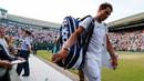 Petenis Spanyol, Rafael Nadal memberikan tanda tangan sambil meninggalkan lapangan usai kalah dari Giller Muller (Luksemburg) di perempat final Wimbledon 2017, Senin (10/7). Nadal kalah dengan skor akhir 3-6, 4-6, 6-3, 6-4, 13-15. (Adrian DENNIS/AFP)