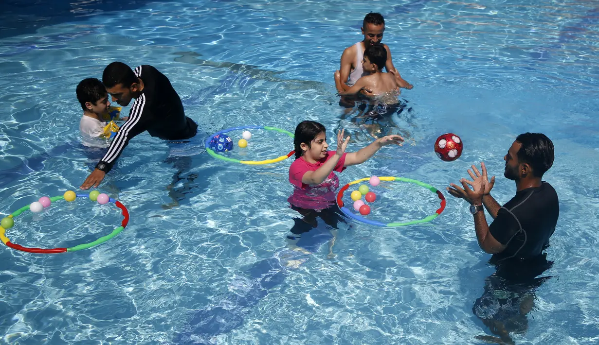Anak-anak Palestina yang menderita autisme berpartisipasi dalam sesi terapi renang di Beit Lahia di Jalur Gaza utara  (5/8/2019). (AFP Photo/Mohammed Abed)