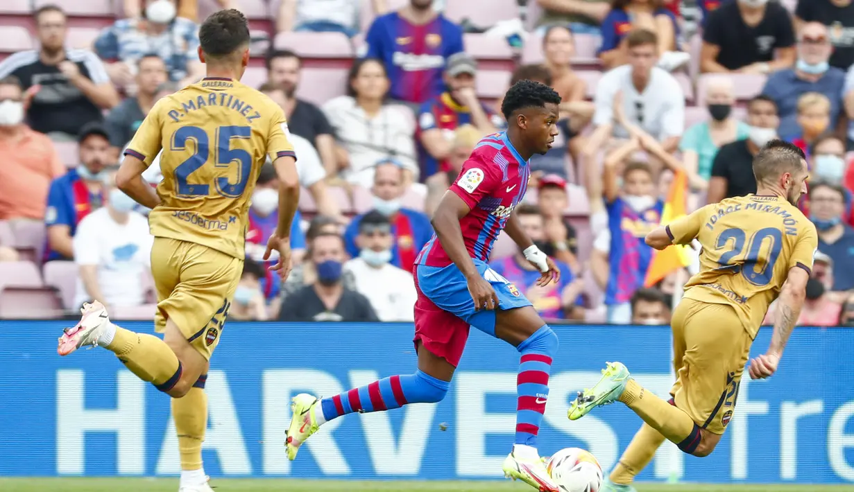 Penyerang Barcelona, Ansu Fati menggiring bola dari kawalan pemain Levante, Jorge Miramon pada pertandingan La Liga Spanyol di Levante di stadion Camp Nou, Spanyol, Minggu (26/9/2021). Kemenangan ini membawa Barcelona naik ke posisi lima klasemen sementara dengan 12 poin. (AP Photo/Joan Monfort)