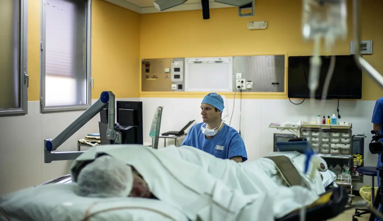 Seorang ahli bedah memperhatikan dengan seksama hasil operasi pasien kanker prostat di layar monitor yang berada didepannya, Rumah Sakit Edouard Herriot di Lyon, Prancis (10/4/2014) (AFP Photo/Jeff Pachoud).