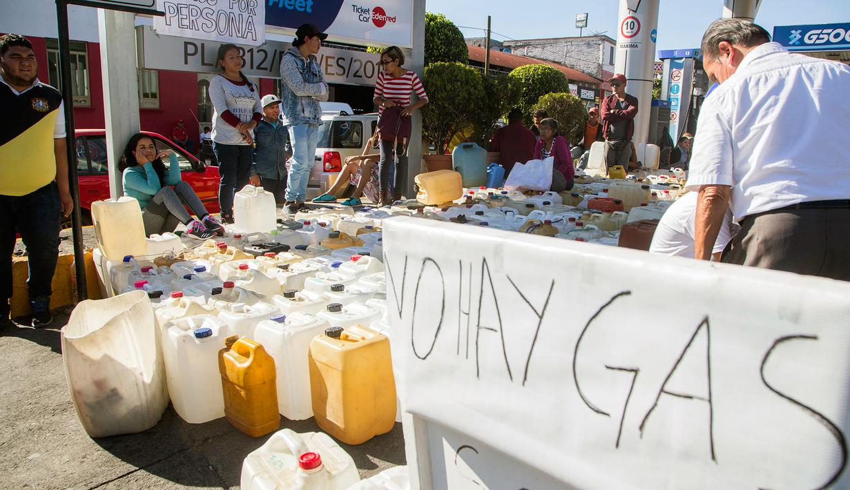 Deretan jerigen warga saat mengantre di tengah kelangkaan BBM di sebuah SPBU di Morelia, Meksiko, Selasa (8/1). Kelangkaan BBM akibat terjadinya pencurian dari jaringan pipa dan dari internal Pemex, perusahaan minyak milik negara. (ENRIQUE CASTRO/AFP)