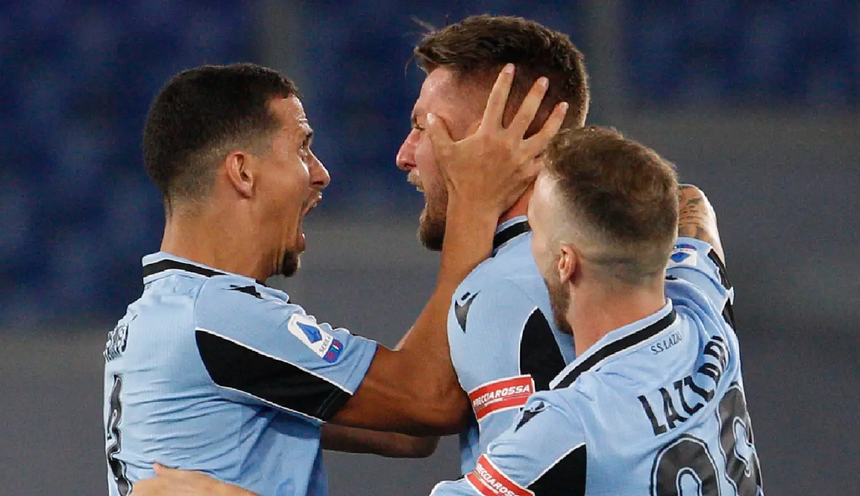 Gelandang Lazio, Sergej Milinkovic-Savic (tengah) berselebrasi dengan rekannya Luiz Felipe dan Manuel Lazzari usai mencetak gol ke gawang Cagliari pada pertandingan lanjutan Liga Serie A Italia di Stadion Olimpiade Roma, di Roma, Italia, Kamis, (23/7/2020). Lazio menang 2-1 atas Cagliari. (AP Photo/
