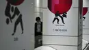Seorang pria yang mengenakan masker pelindung untuk mencegah penyebaran virus corona berjalan di depan iklan Olimpiade Tokyo 2020 di Tokyo, Rabu (17/3/2021). Ibukota Jepang mengonfirmasi lebih dari 400 kasus virus korona baru pada hari Rabu. (AP Photo/Eugene Hoshiko)