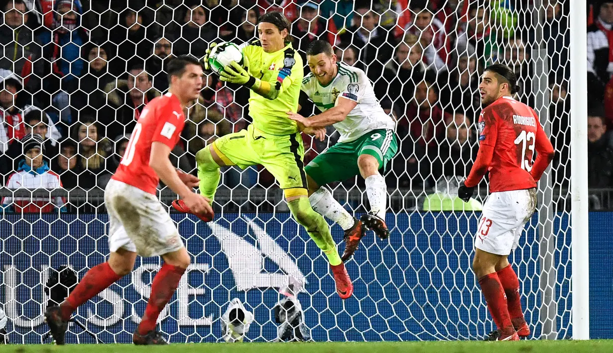 Kiper Swiss, Yann Sommer berhasil menangkap bola pada leg kedua fase playoff Piala Dunia 2018 zona Eropa melawan Irlandia Utara di St Jakob Park Stadium, Minggu (12/11). Swiss unggul agregat 1-0 atas Irlandia Utara. (Jean-Christophe Bott/Keystone via AP)