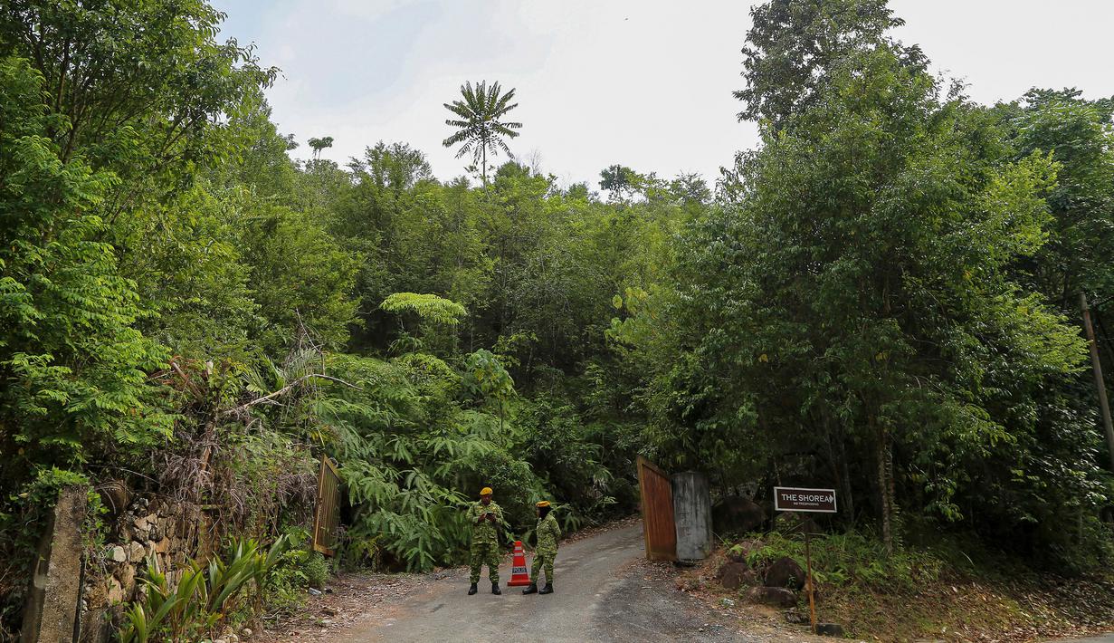 Anggota Korps Sukarelawan Rakyat (RELA) berjaga saat tim penyelamat menggelar operasi pencarian gadis disabilitas asal Irlandia Nora Anne Quoirin yang hilang dari sebuah resor hutan hujan di Seremban, Malaysia, Rabu (7/8/2019). (AP Photo/Annice Lyn)