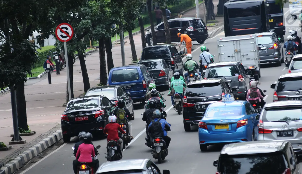 Pengendara motor melintas di sisi mobil parkir di jalur khusus motor di sekitar Jalan Medan Merdeka Barat, Jakarta, Kamis (1/3). Jalur yang seharusnya digunakan untuk pengendara motor tersebut hingga kini belum steril. (Liputan6.com/Helmi Fithriansyah)