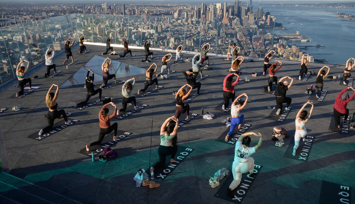 Praktisi yoga menghadiri kelas di Edge Observation Deck, Manhattan, New York, Amerika Serikat, Kamis (17/6/2021). Edge Observation Deck disebut sebagai 'dek langit luar ruang tertinggi di Belahan Barat'. (Ed JONES/AFP)